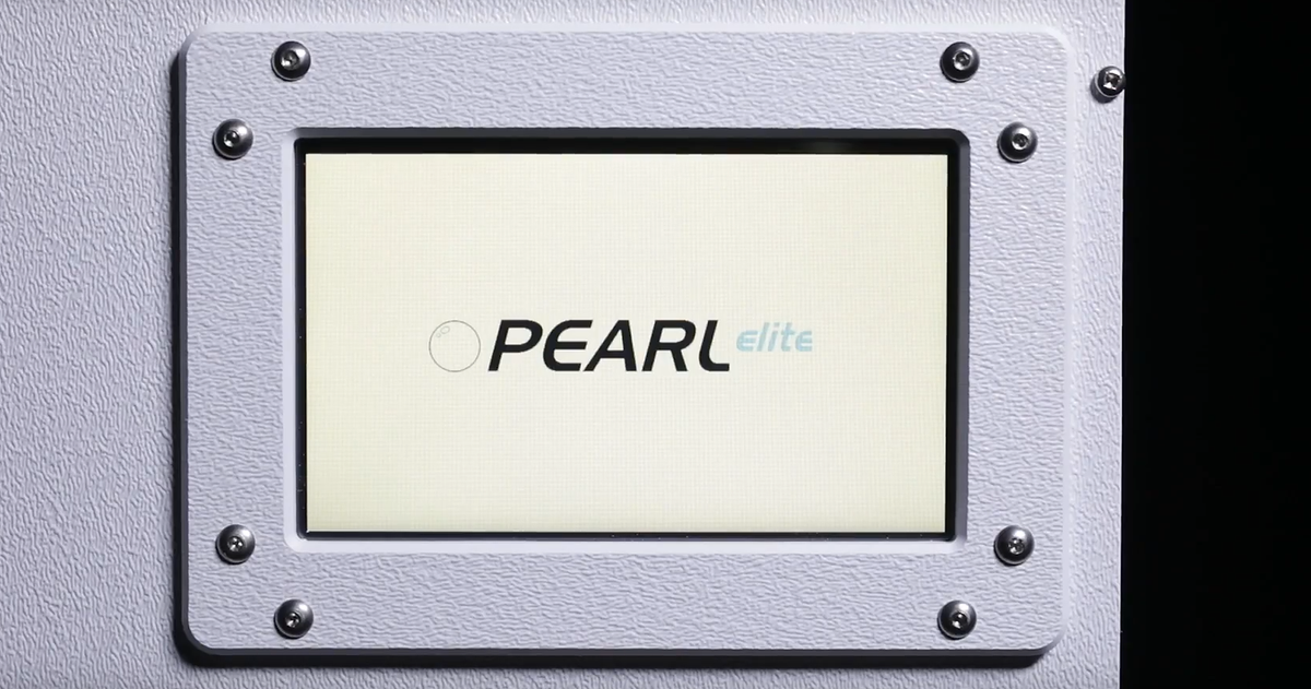 A close-up of a textured light gray panel with a central square inset displaying the brand name &